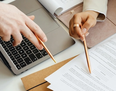 Les mains d'un homme et d'une femme analysant un document, illustrant le service de gestion des ressources humains à Lille d'Anne-Sophie Billaud
