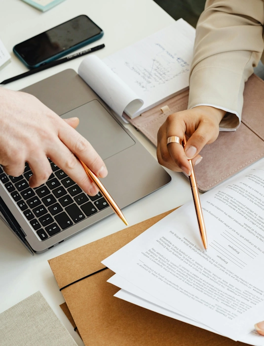 Les mains d'un homme et d'une femme analysant un document, illustrant le service de gestion des ressources humains à Lille d'Anne-Sophie Billaud